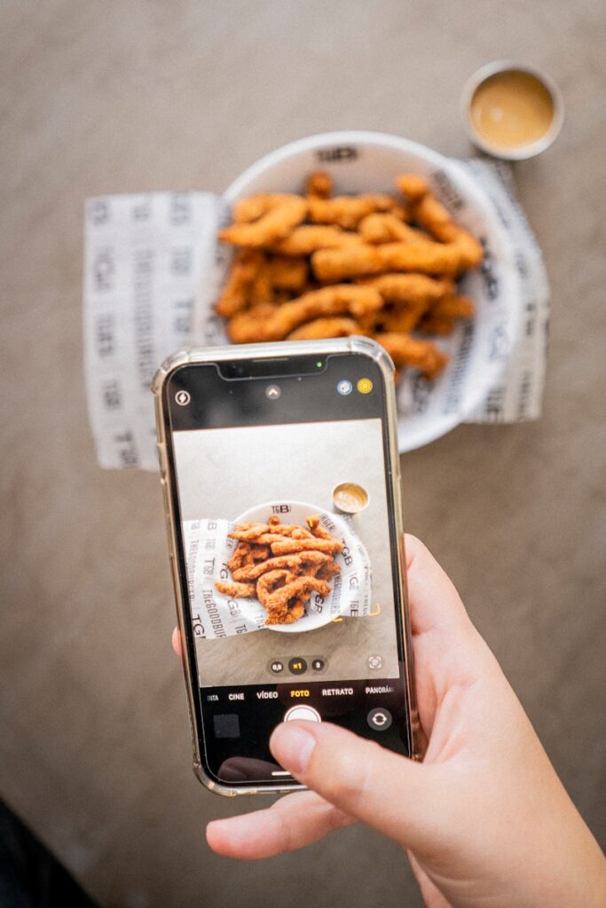 a person taking a picture of a plate of food